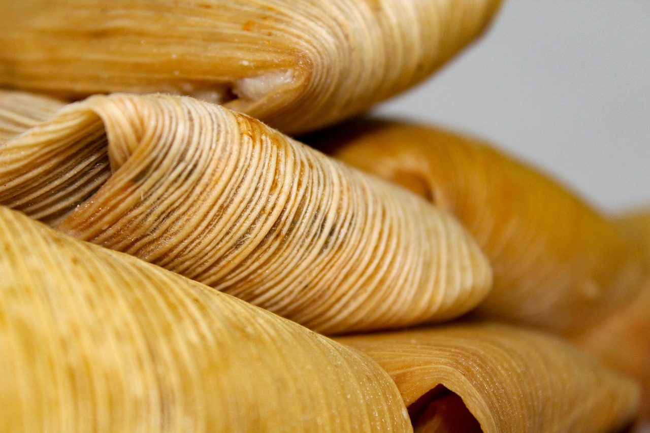 Tamales w liściach kukurydzy otwarte na talerzu
