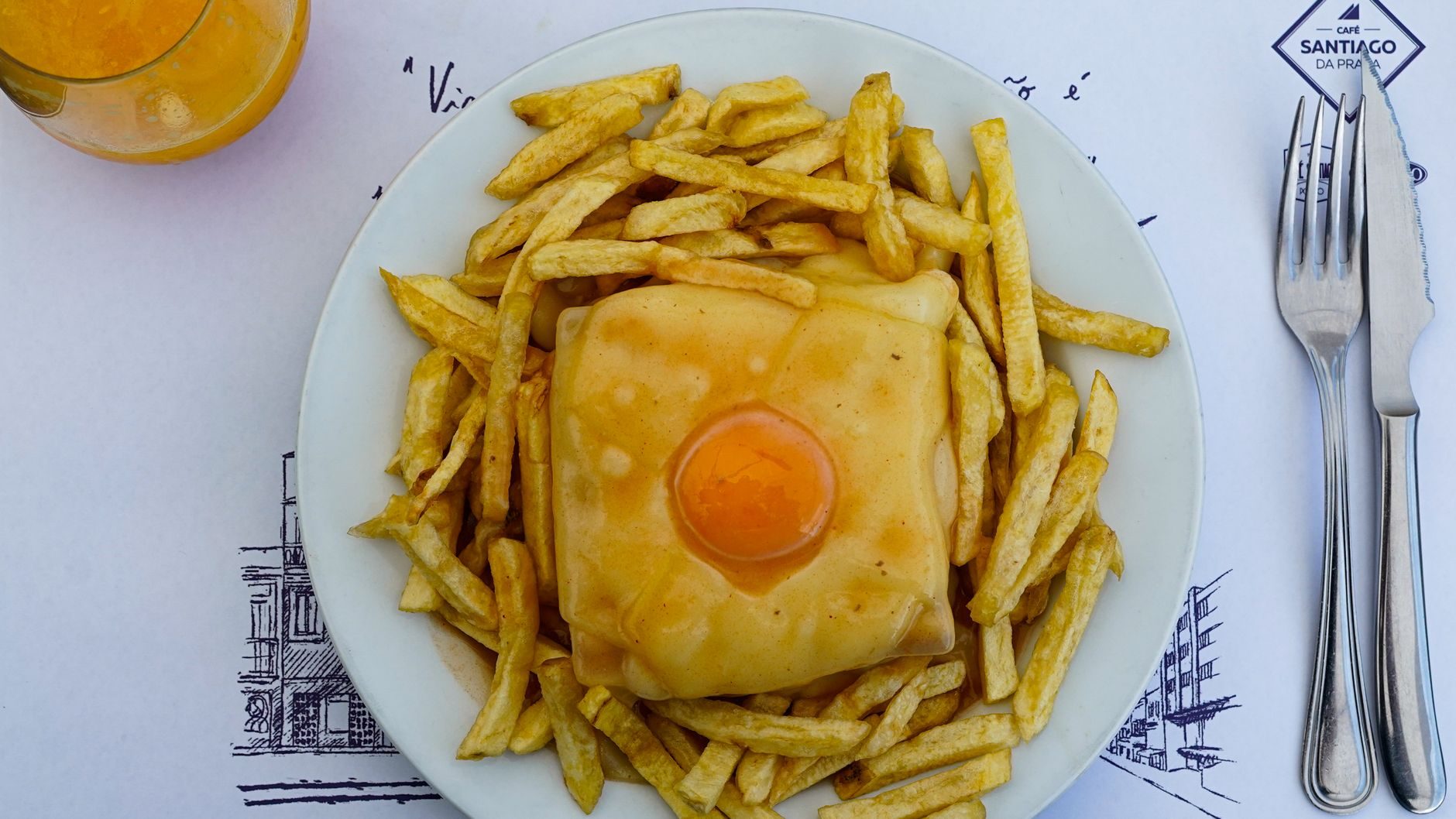 kanapka francesinha zalana pomarańczowym sosem z jajkiem sadzonym