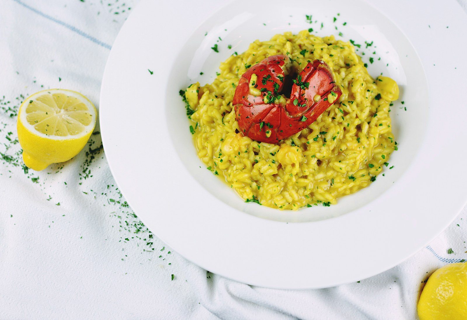 złote kremowe risotto rozlewające się płasko na białym talerzu