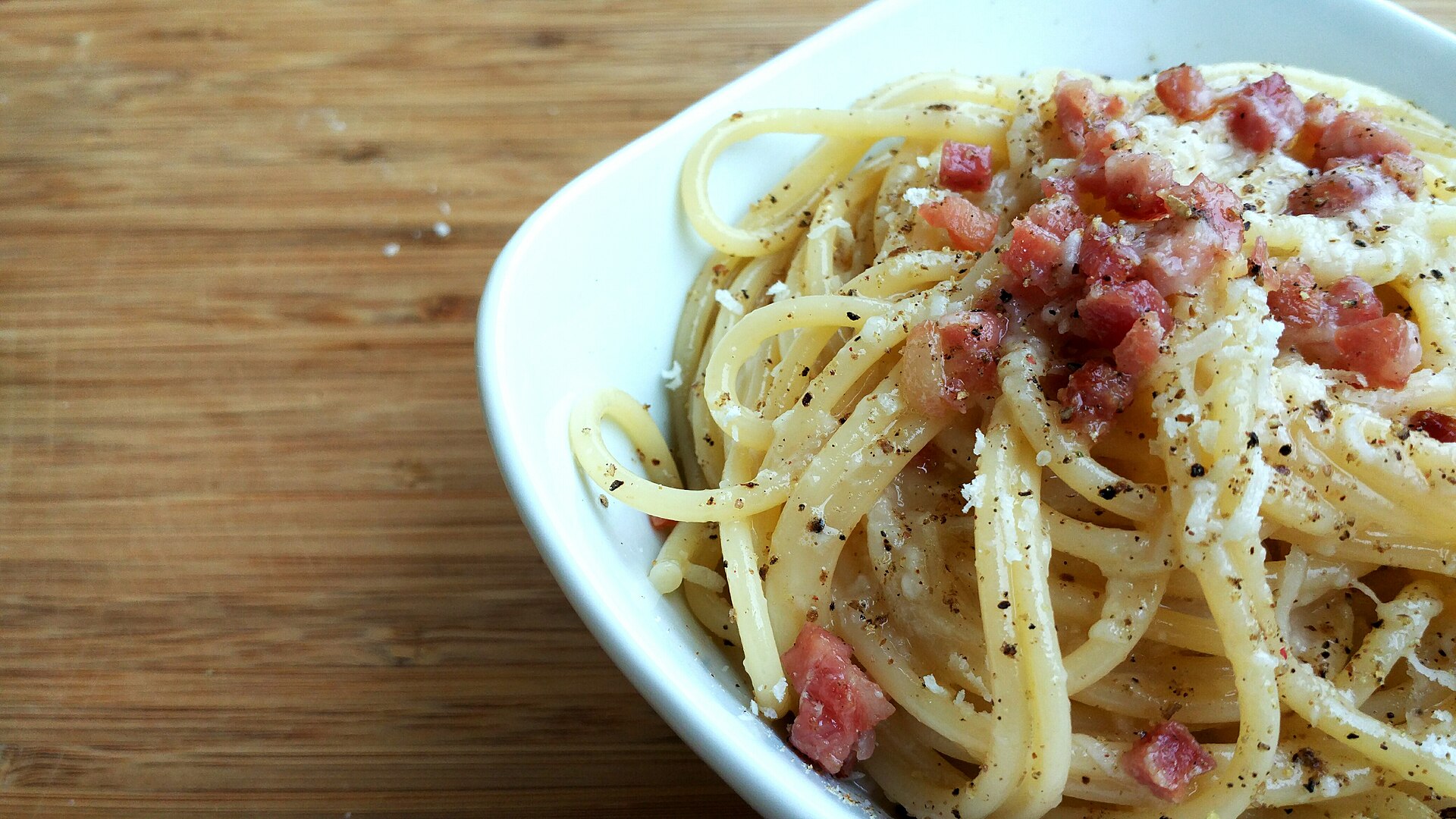 talerz spaghetti carbonara z grubo mielonym pieprzem i wiórkami pecorino