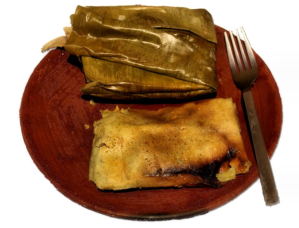 Tamales w liściach kukurydzy otwarte na talerzu