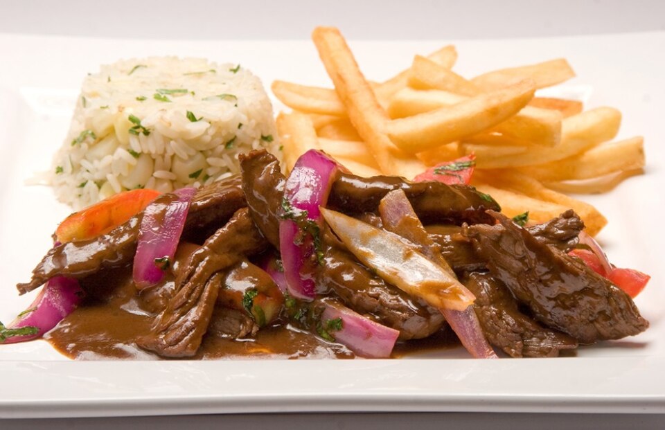 Lomo saltado z frytkami i ryżem na talerzu